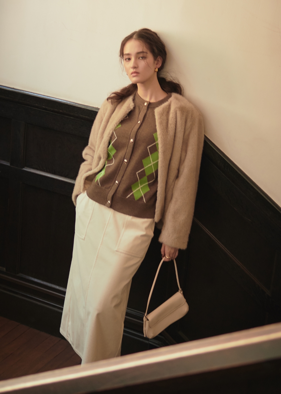 ベージュのファージャケット・ブラウンのアーガイルカーディガン・アイボリーのコーデュロイスカートを着用した女性の画像--1