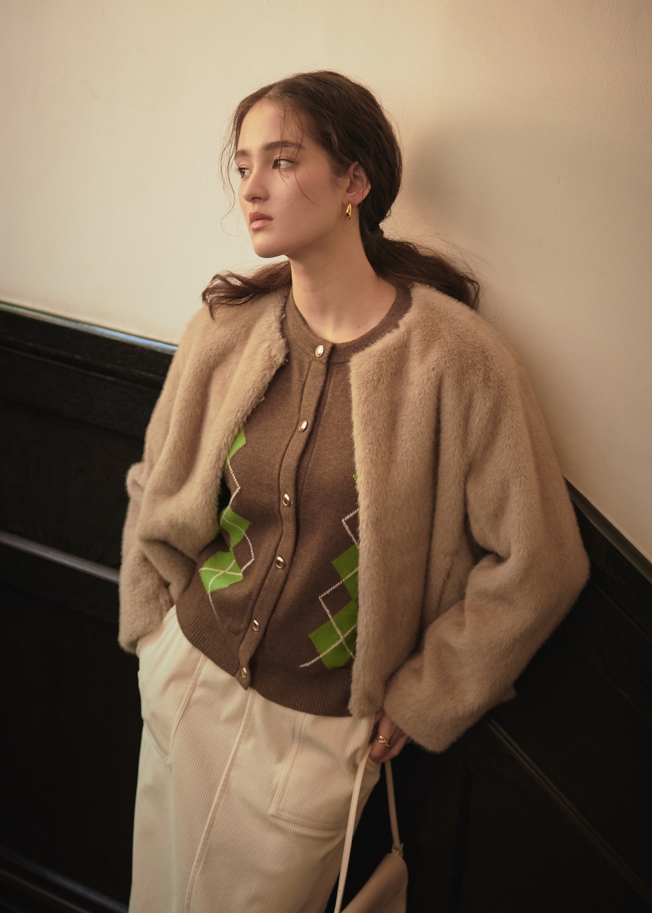 ベージュのファージャケット・ブラウンのアーガイルカーディガン・アイボリーのコーデュロイスカートを着用した女性の画像--2