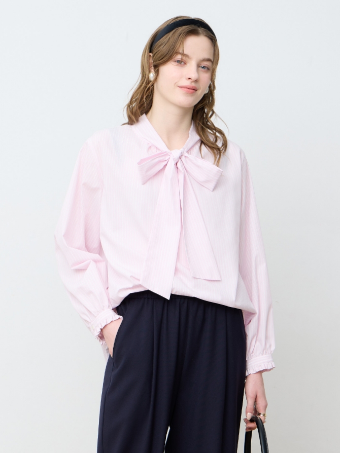 LE SOUK HOLIDAY ボウタイブラウスを着用した女性