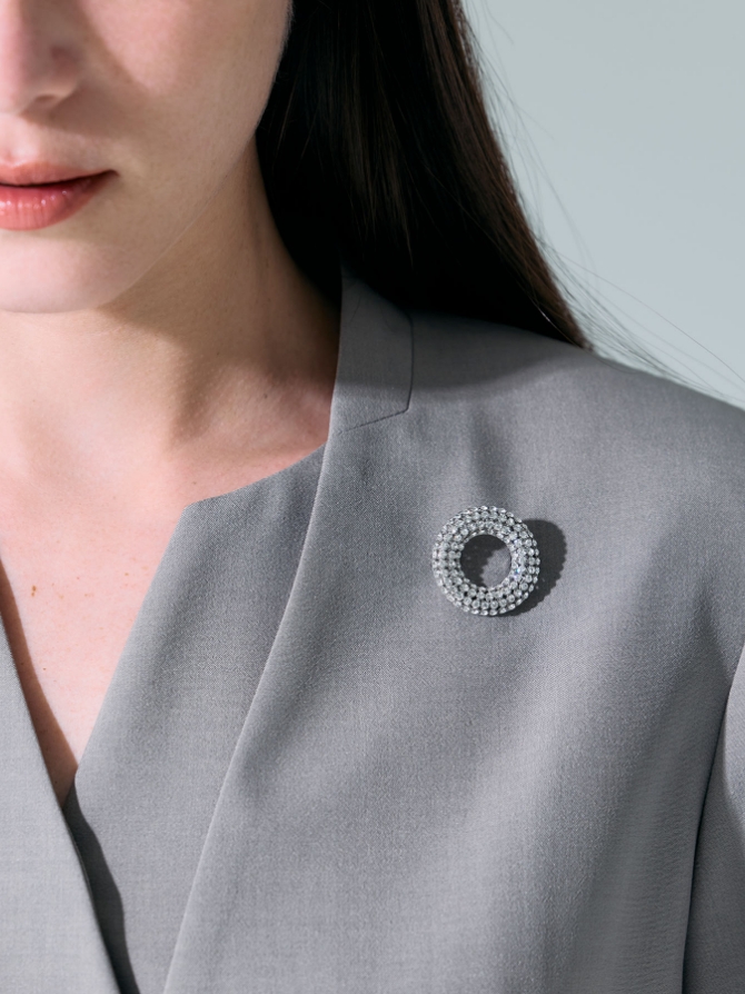 N.O.R.C サークルビジューブローチを着用した女性