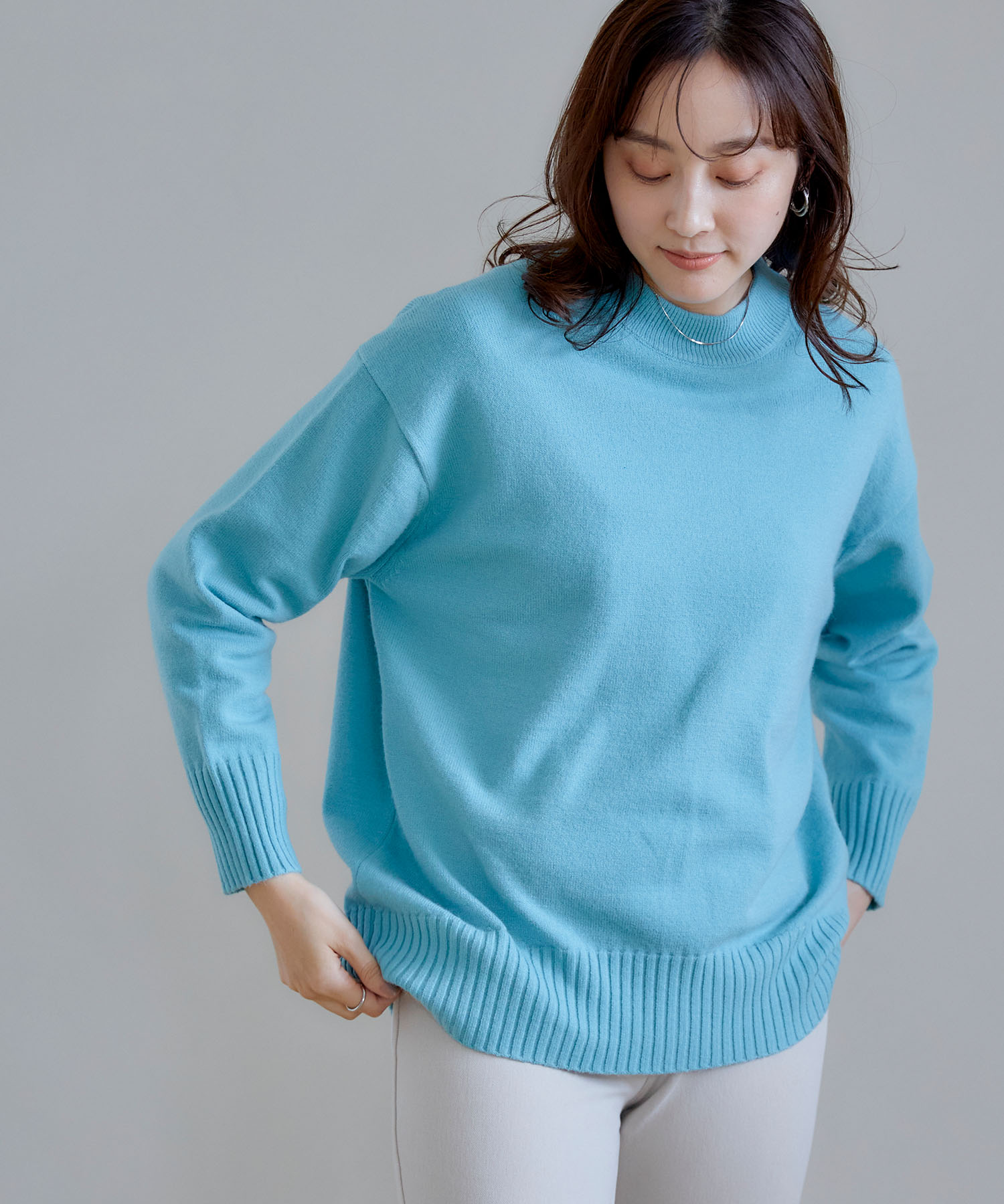 CROSS FUNCTION《洗える》エブ楽 バックスリットニットを着用した女性