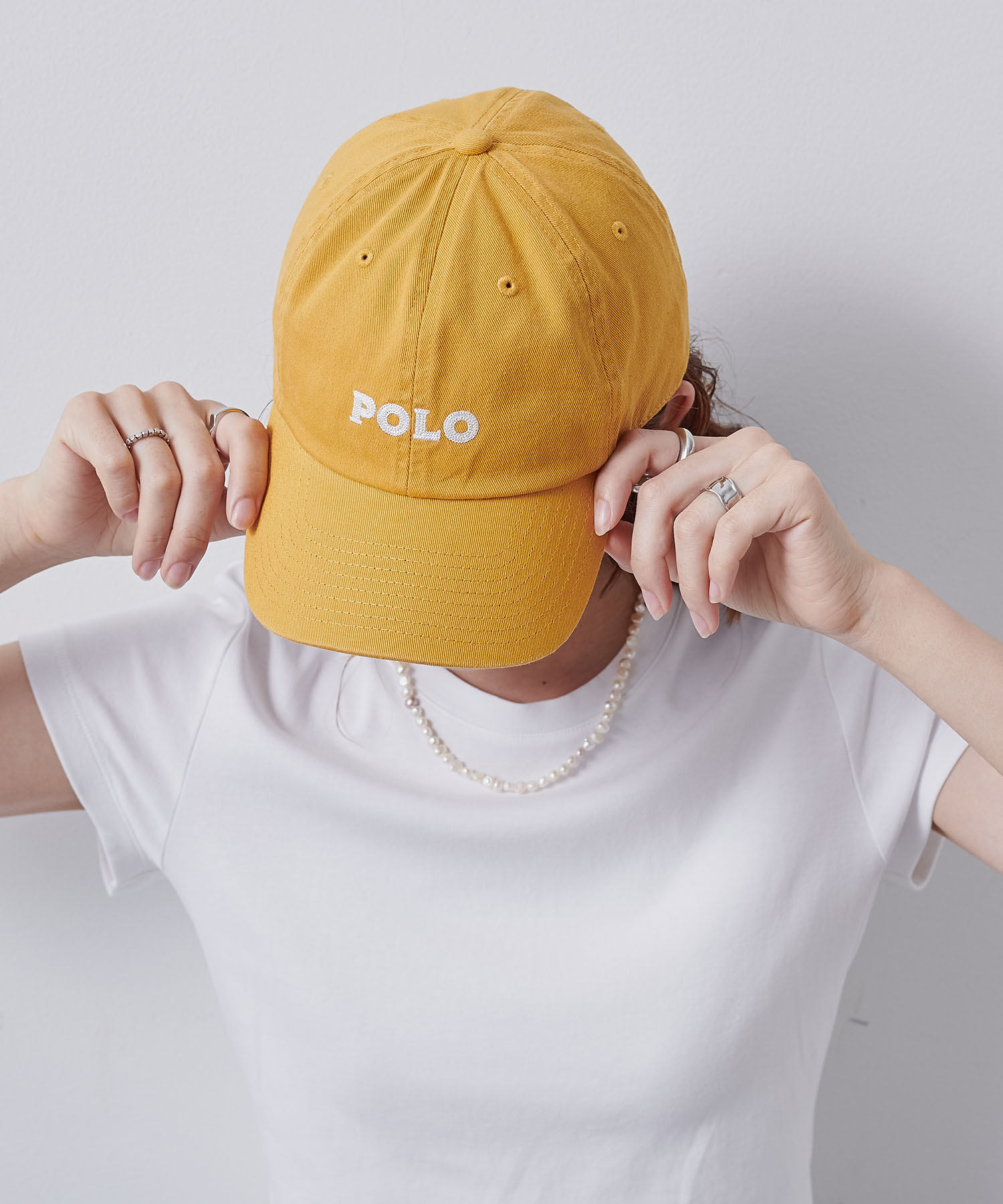 CROSS FUNCTION POLO刺繍キャップを着用した女性