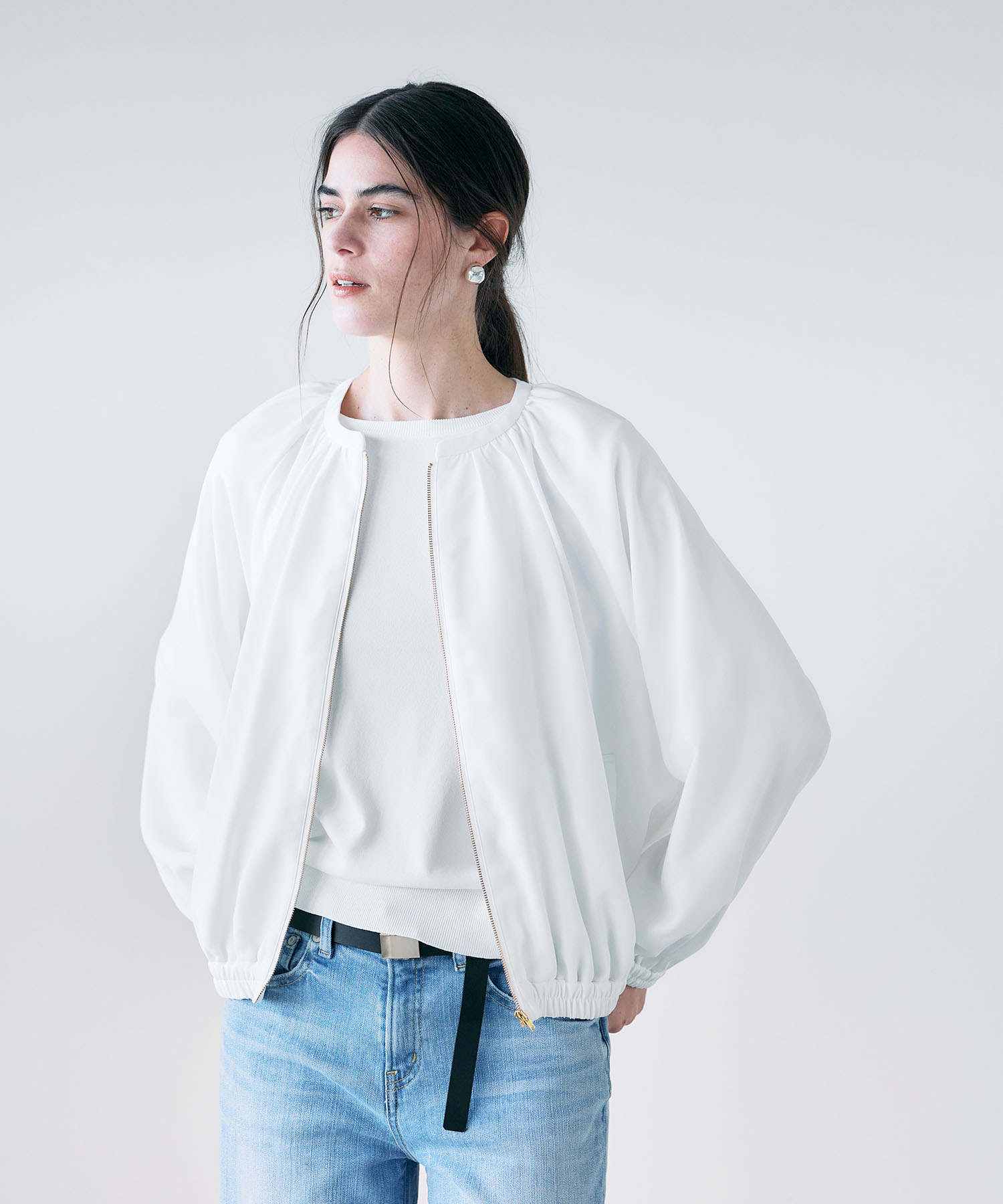  N.O.R.C バックサテンストレッチブルゾンを着用した女性