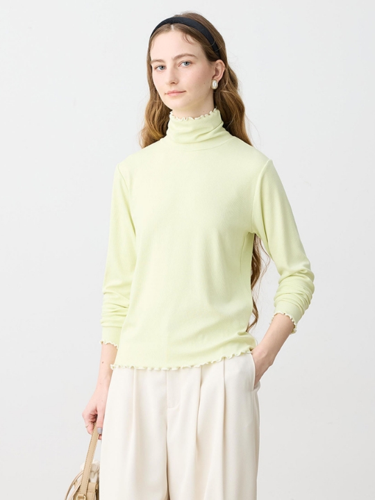 バイカラーメローハイネックプルオーバーを着用した女性