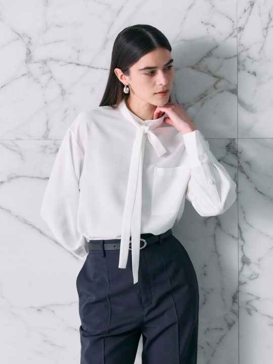 バックサテンストレッチボウタイブラウスを着用した女性