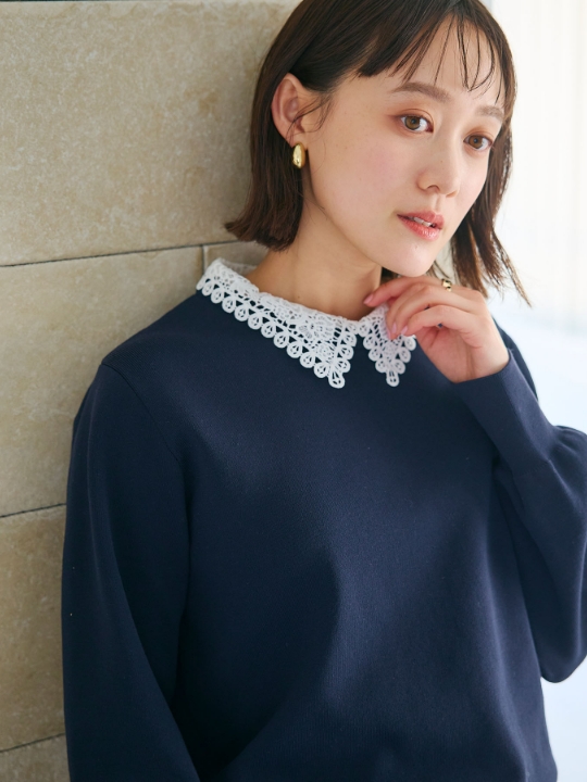 レース襟ニットプルオーバーを着用した女性