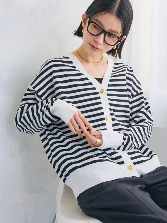《洗える》金釦ボーダーVネックカーディガンを着用した女性