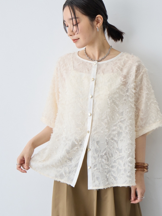 ニュアンス柄シアージャガードブラウスを着用した女性