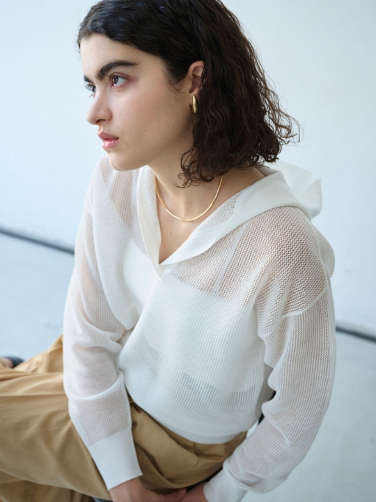 メッシュニットフーディーを着用した女性