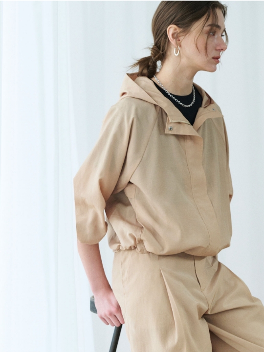 ベージュのブライトローン撥水ブルゾン【AIRY MOTION】・ベージュのパンツを着用した女性