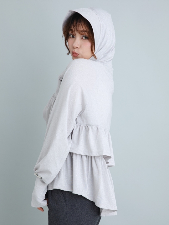 ピンクのラメ生地フード付きバックフリルパーカ・ブラックのパンツを着用した女性