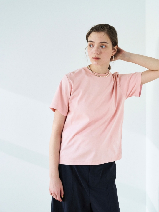 ピンクの【マルチファンクション】Tシャツ・ブラックのパンツを着用した女性