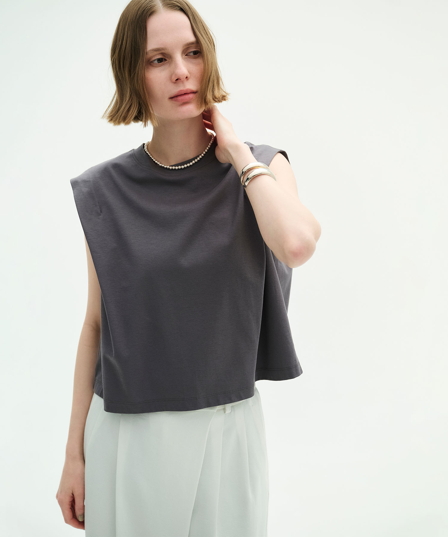 N.O.R.C 【マルチファンクション】タックショルダートップスを着用した女性