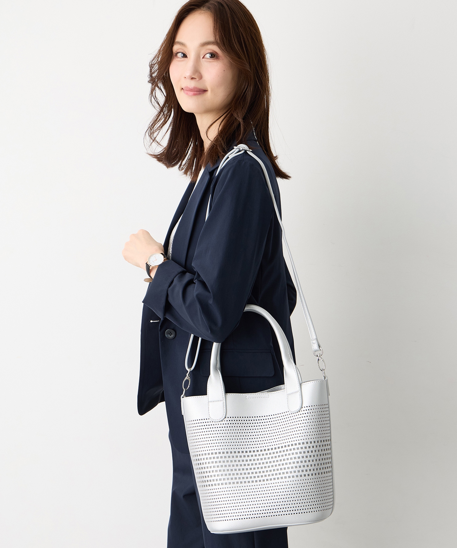 A/C DESIGN BY ALPHA CUBIC パンチング合皮2WAYトートバッグを着用した女性