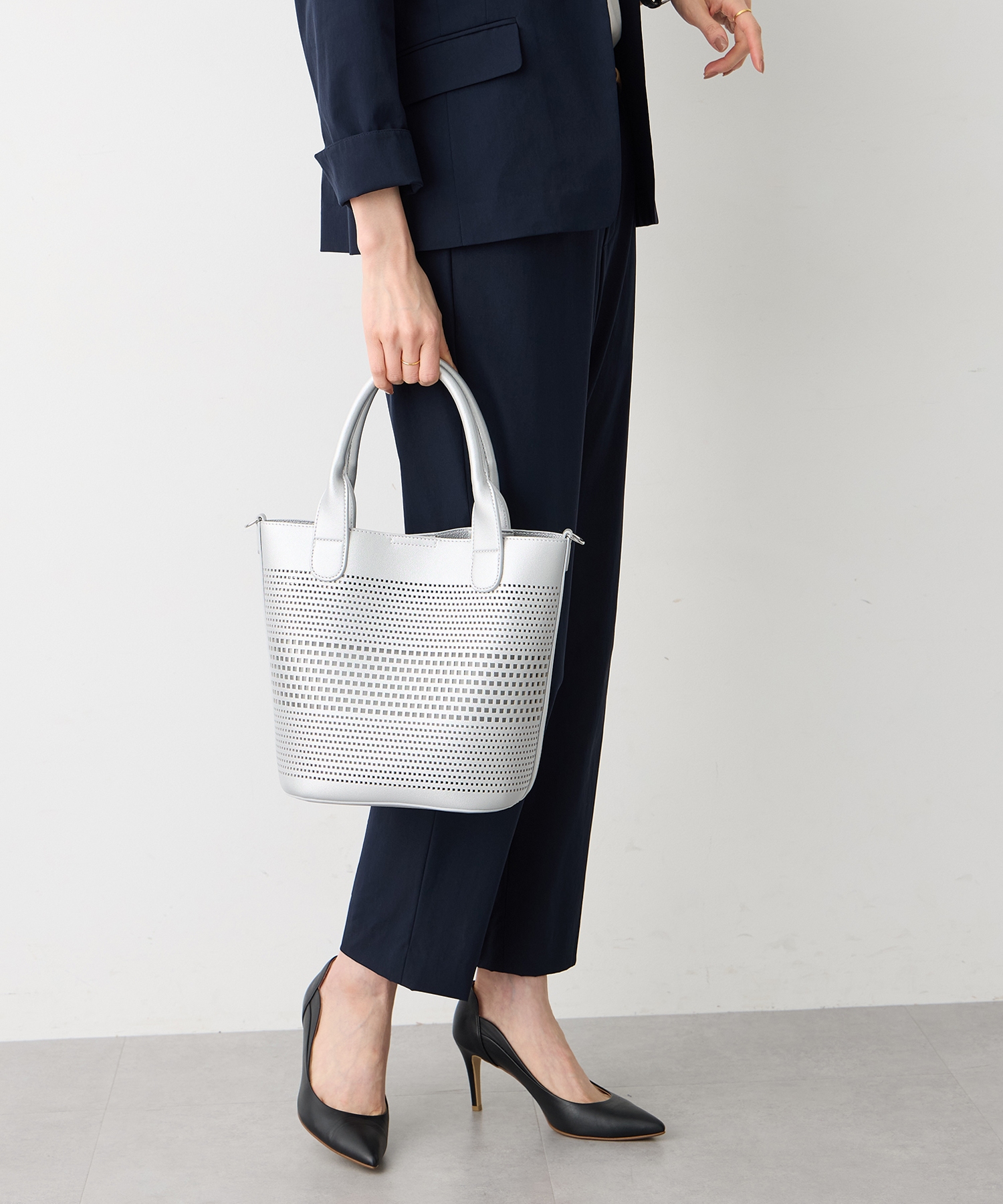 A/C DESIGN BY ALPHA CUBIC パンチング合皮2WAYトートバッグを着用した女性