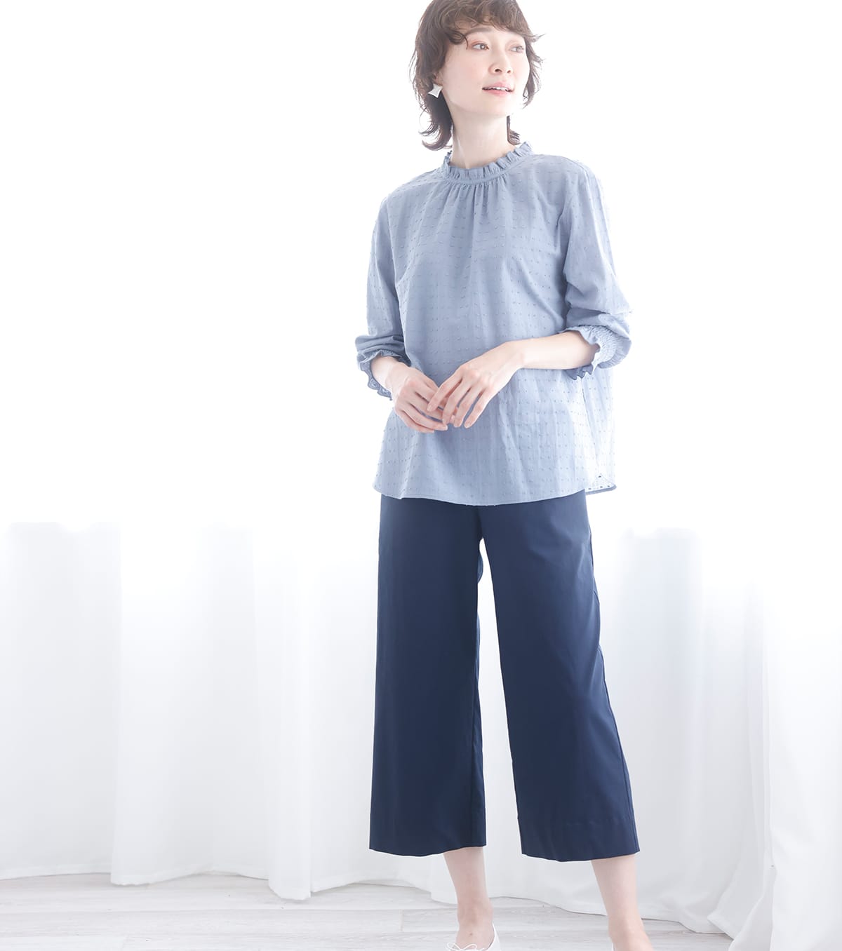 シャーリングスモック・ブルーを着用している女性の写真