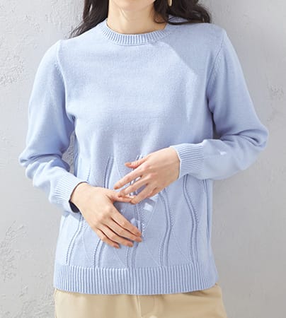 透かし編みニットプルオーバーを着用した女性の横向きの写真