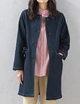 ステンカラーデニムロングコートを着用した女性の写真