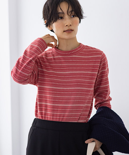 レッド色のジャガードボーダーハイネックプルオーバーを着用した女性のイメージ