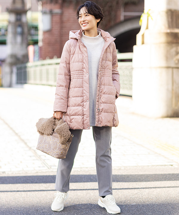 ピンクのロングダウンコートを着用した女性の画像（アンカーリンク）