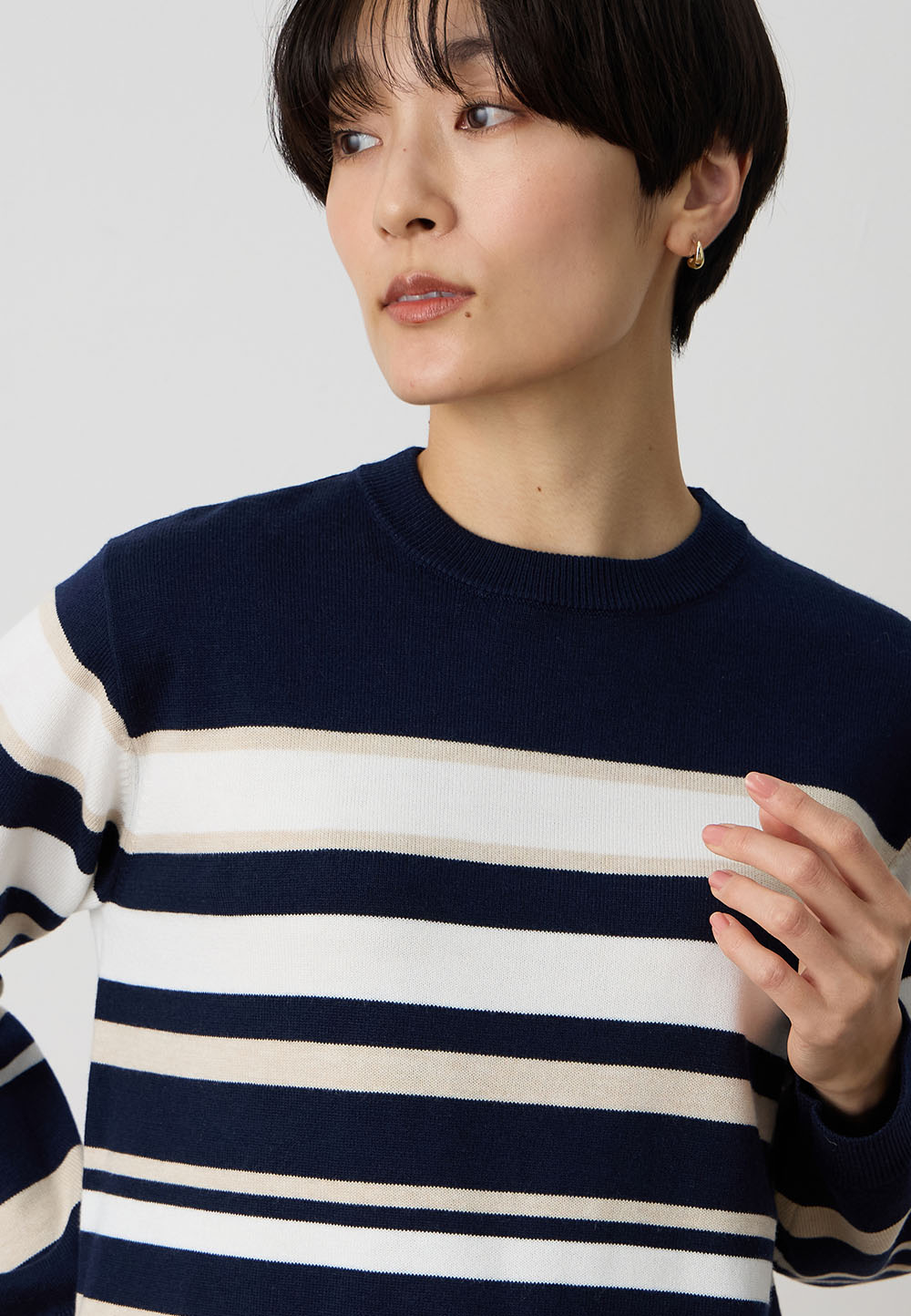 パネルボーダーニットプルオーバー&裏付きストレートパンツ、ライナー付きコートを着用した女性 01