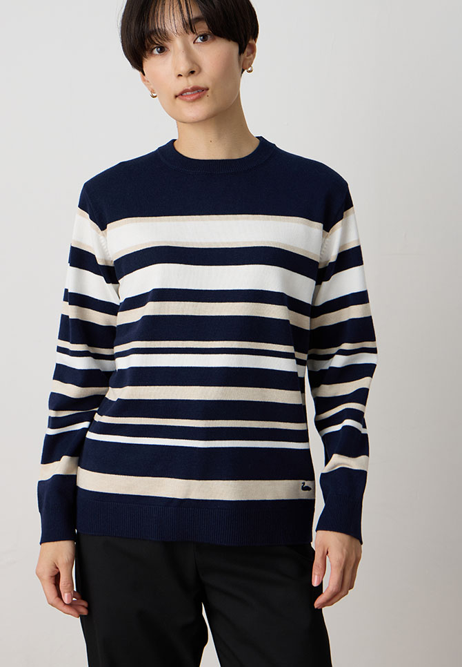 パネルボーダーニットプルオーバー&裏付きストレートパンツを着用した女性