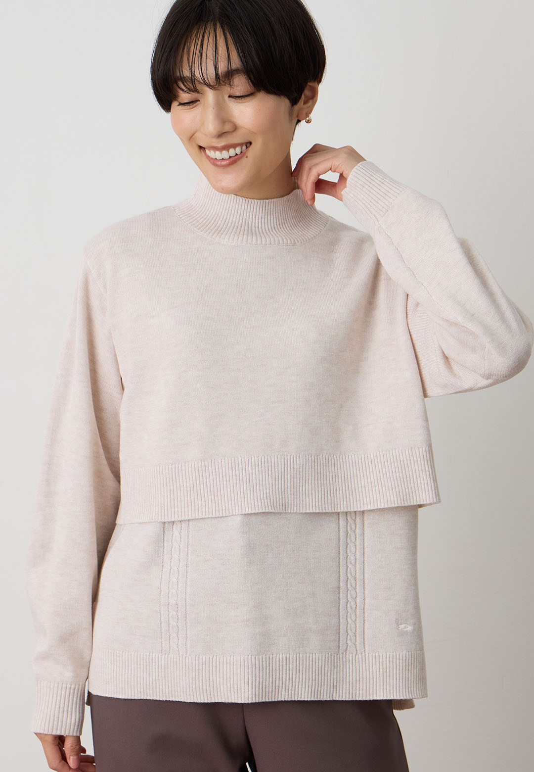 ハイネックニットアンサンブル&裏付きストレートパンツを着用した女性 02