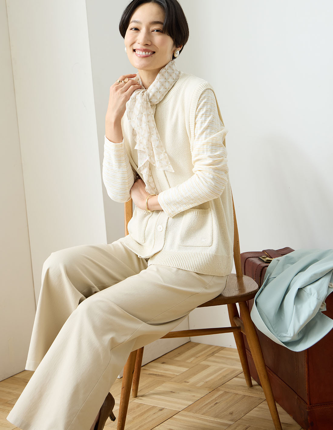 Departure Blue ボラメニットベスト&ストレッチワイドパンツ&モノグラムストール&を着用した女性 02