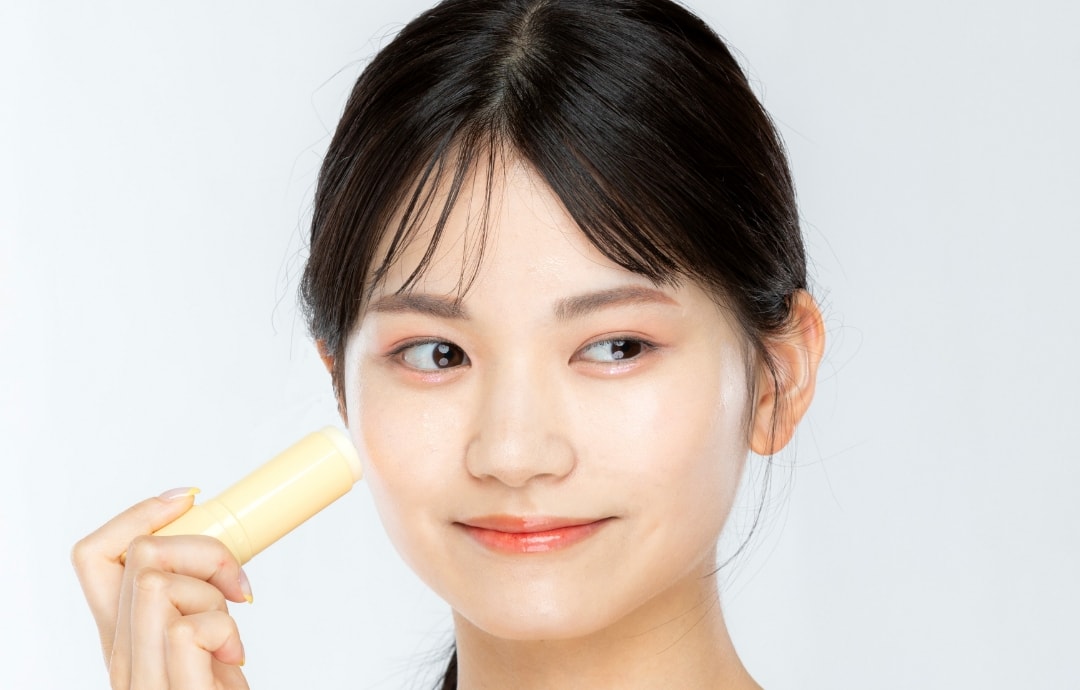 コラーゲンモイスチャーSUNマルチバームを手に持っている女性の写真２
