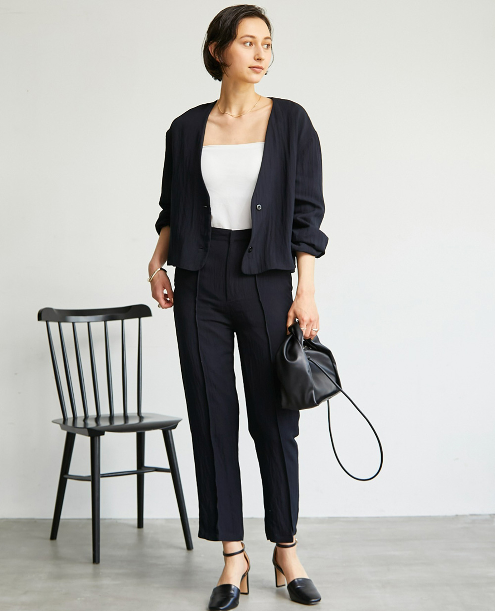 【yun_wearコラボ】ノーカラージャケット＋センターラインピンタック　セットアップの黒を着用して正面を向いた女性の写真