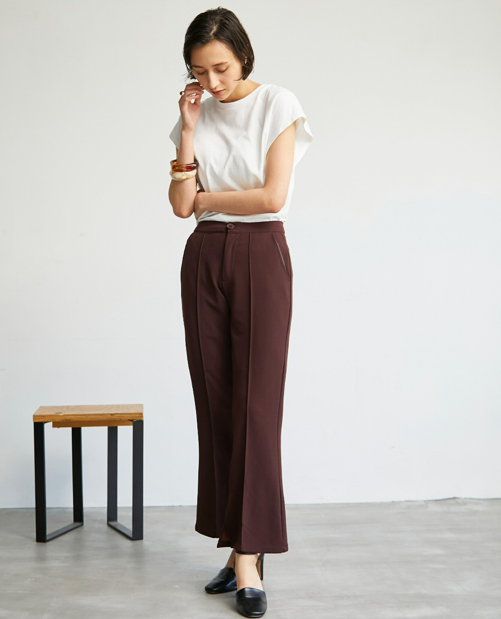 【yun_wearコラボ】サイドスリットカットソーツイルカラーパンツの茶を着用して正面を向いた女性の写真