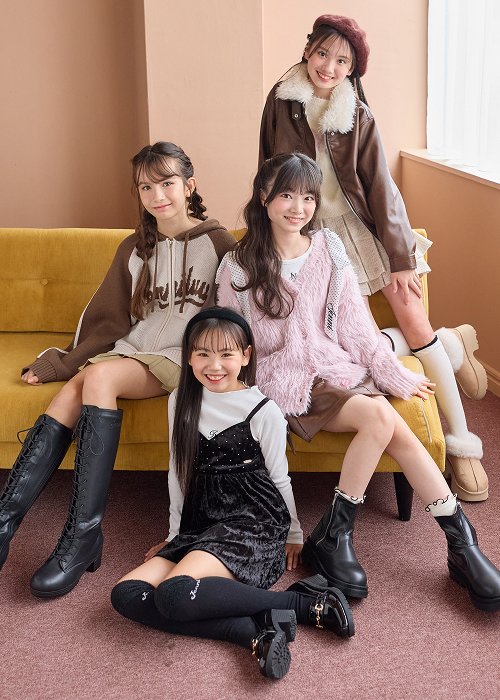ソファに座るブラウンのボアジャケットやピンクのシャギーカーディガンを着た4人の女の子