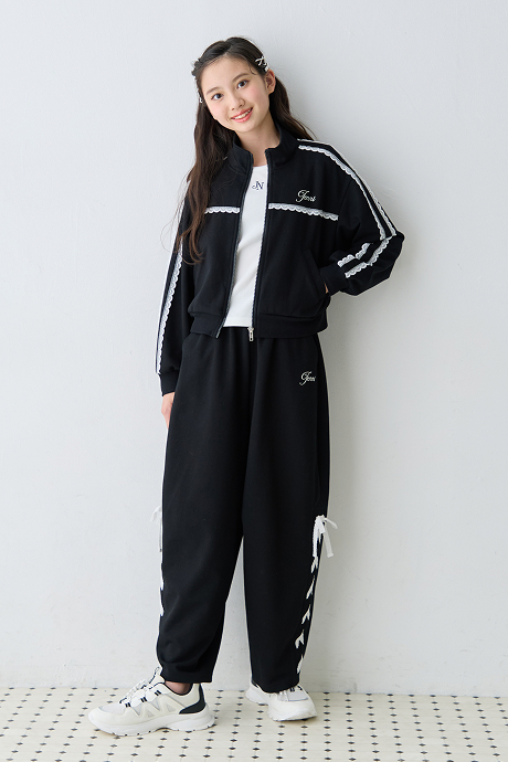 黒のジャージセットアップに白スニーカーを合わせた女の子