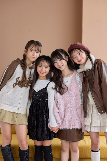 ブラウンとピンクのアウターを着たMuseメンバー4人