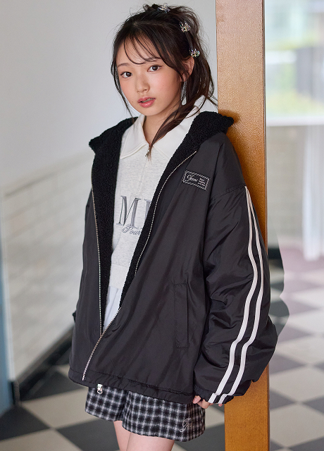 黒のボア×タフタリバーシブルブルゾンを羽織って立つモデル