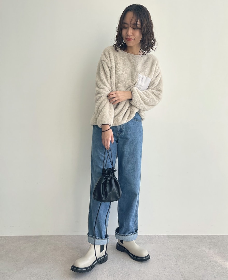 片ポケフリースプルオーバーを着用して立っている女性の写真