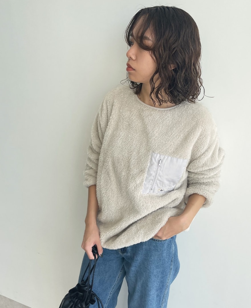 片ポケフリースプルオーバーを着用してパンツのポケットに手を入れている女性の写真