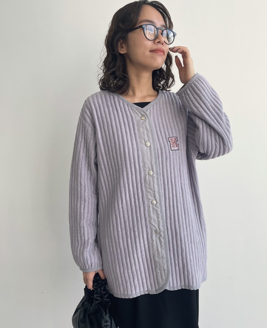 タフタ使いキルトジャケットを着用して斜め上を向く女性の写真