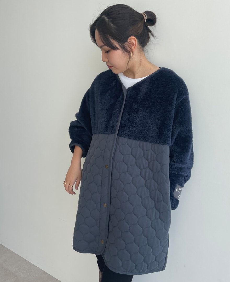 キルト切替アウターを着用して、アウターの袖をまくる女性の写真