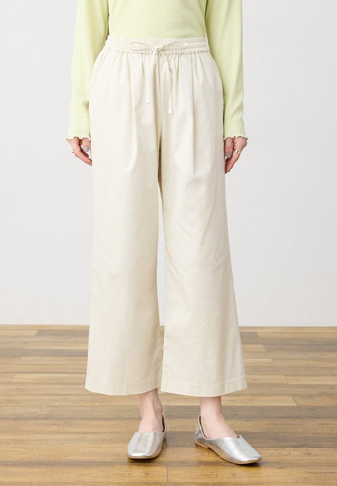 オフホワイト色のストレッチタックワイドパンツの着用イメージ