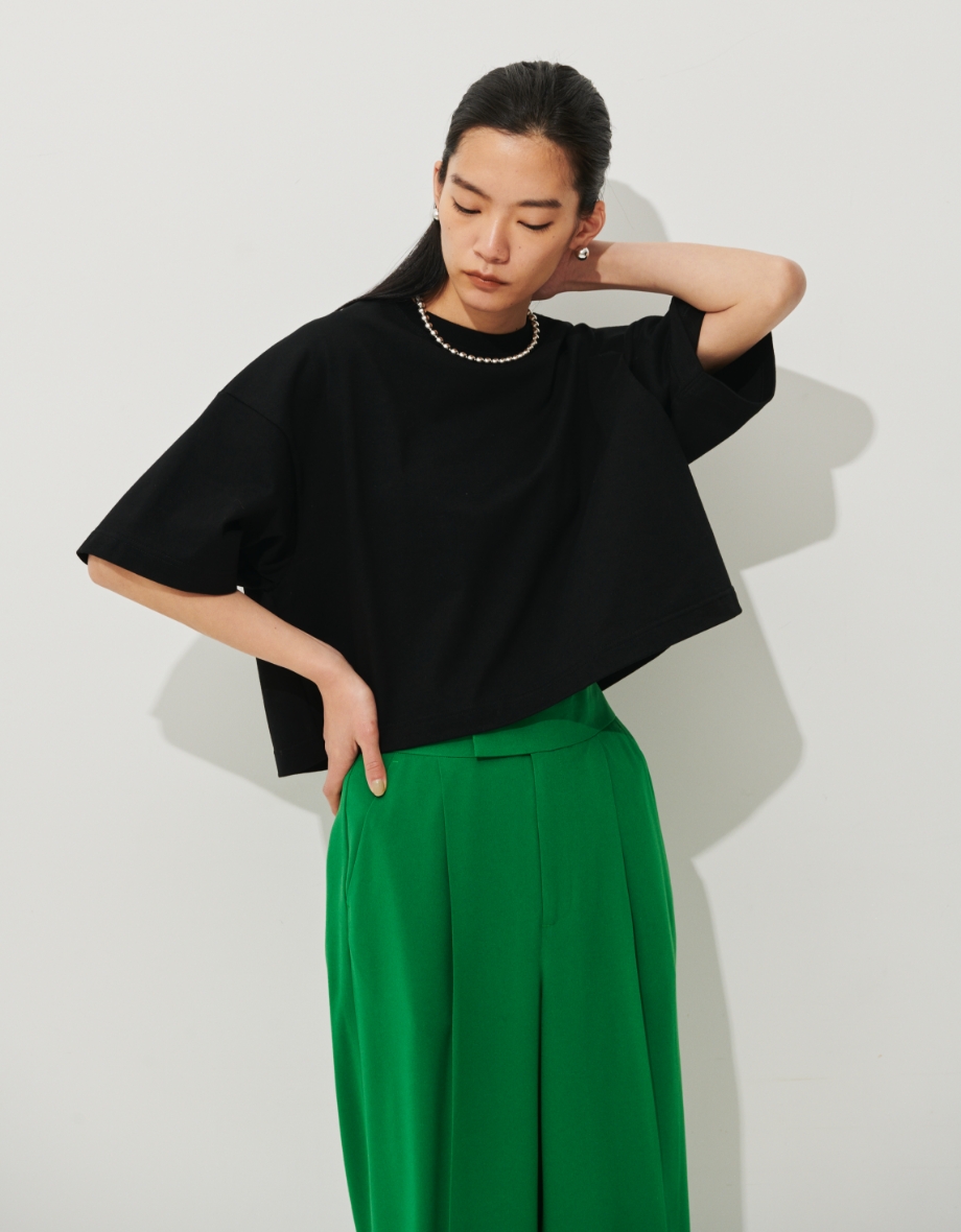 ハイゲージクロップトTシャツ、バックサテンカラーワイドパンツを着用している女性の写真