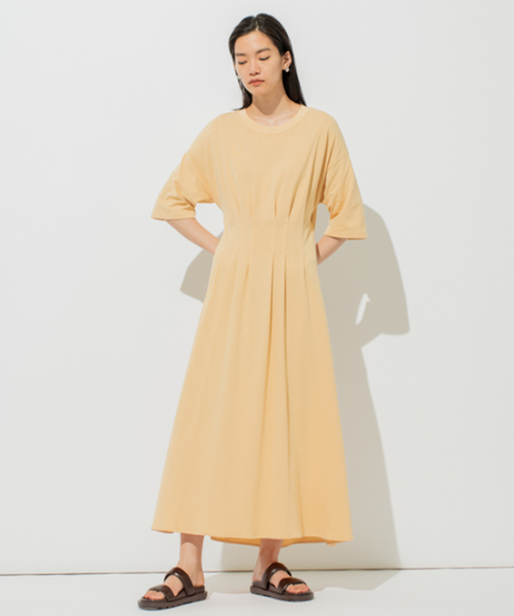 タックマークTワンピースのオレンジを着用している女性の写真