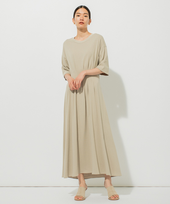 タックマークTワンピースのグレーを着用している女性の写真