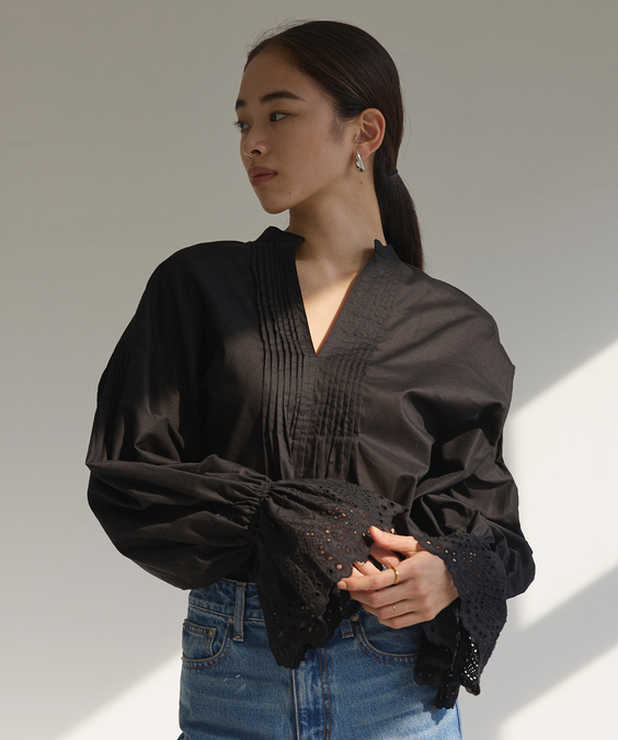 カットワーク刺繍ブラウスのブラックを着用している女性の写真