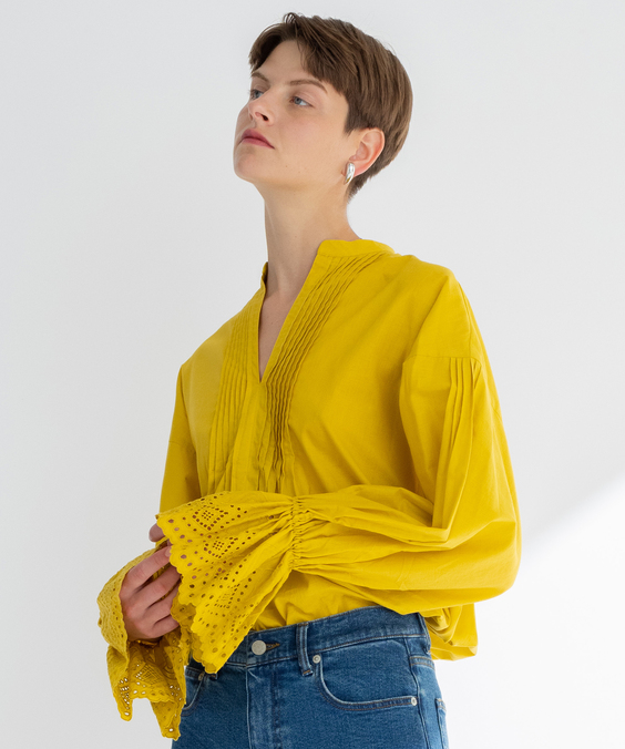 カットワーク刺繍ブラウスのシトラスを着用している女性の写真