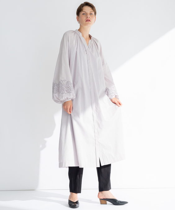 カットワーク刺繡ワンピースのペールライラックを着用している女性の写真