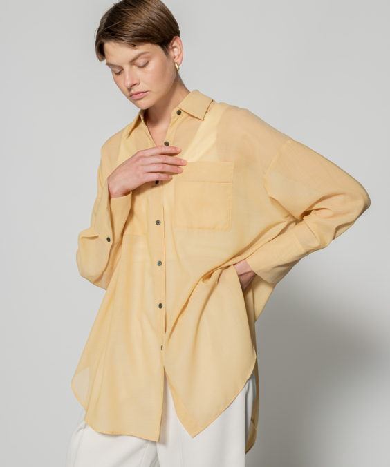 シアーオーバーシャツのイエローを着用している女性の写真