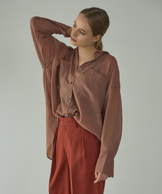 シアーオーバーシャツのピンクを着用している女性の写真