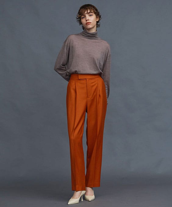 ワンタックストレートパンツのオレンジを着用している女性の写真