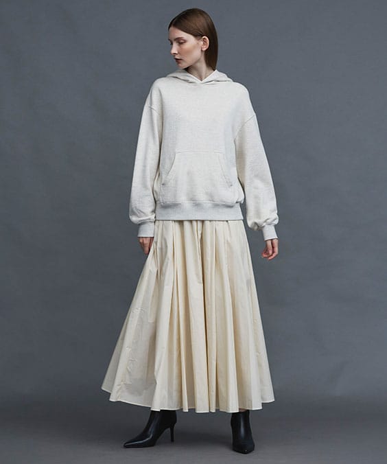 ランダムタックフレアースカートのエクリュを着用している女性の写真